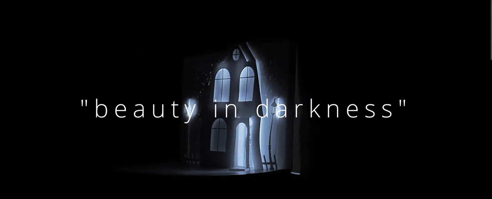 Im Vordergrund ist der Schriftzug "beauty in darkness" zu sehen. Im Hintergrund sieht man eine nächtliche Häuserzeile mit einer Straßenlaterne davor.