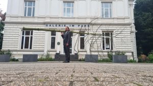 Jan Philip Scheibe steht mit der Fichte vor dem Eingang der Galerie im Park.