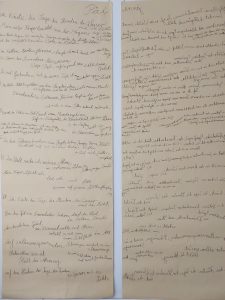 Zwei Papierbahnen an einer Wand. Dort steht Text geschrieben. Auf dem rechten Papier ist die Schrift spiegelverkehrt.