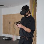 Ein Mann mit VR-Brille und dazugehörigen Controllern