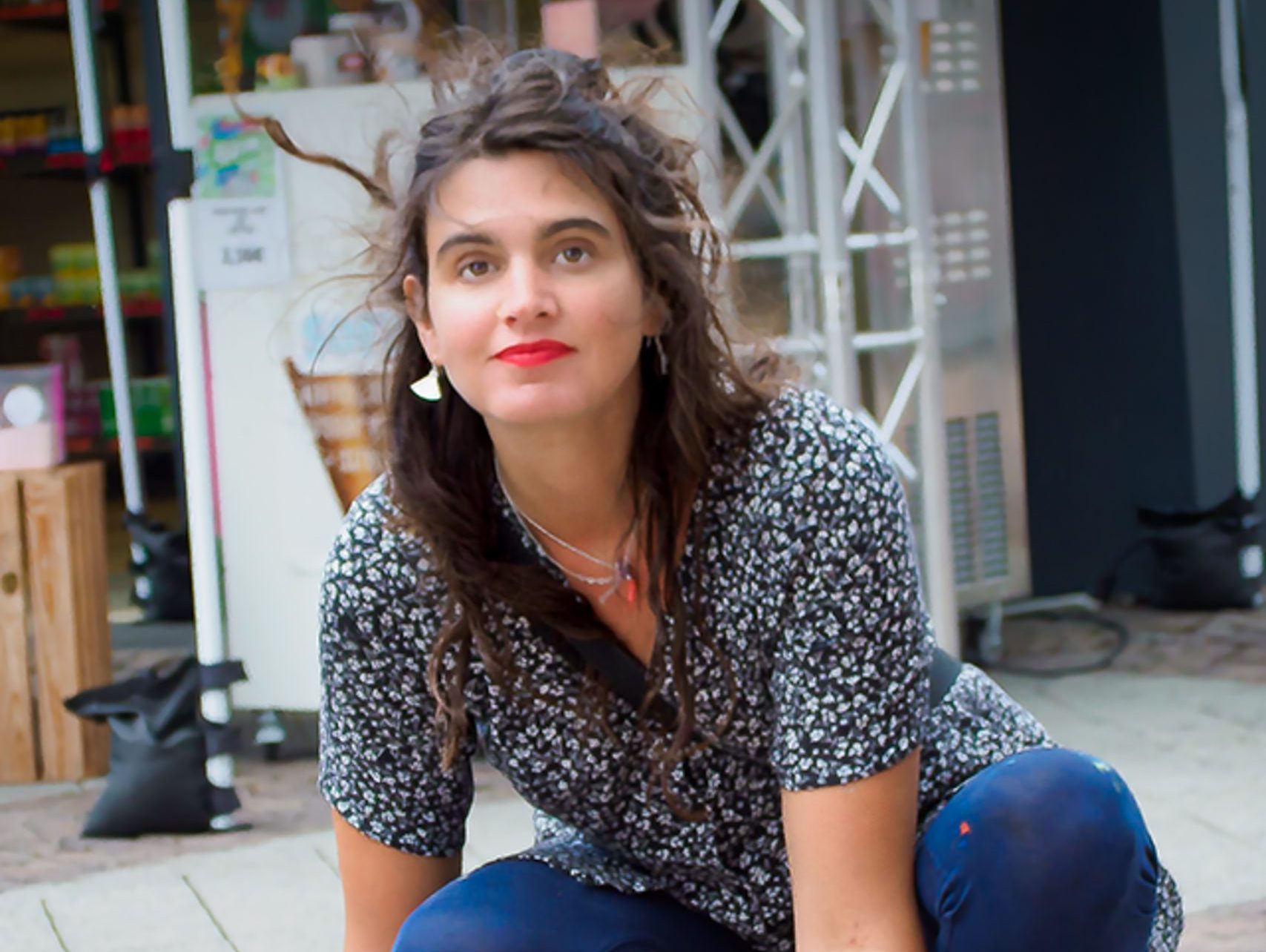 Eine junge Frau hockt am Boden.